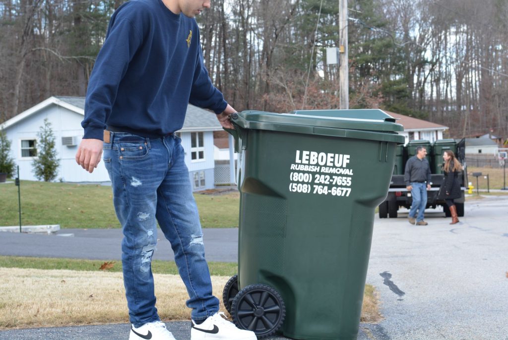 LeBoeuf staffer setting out a new recycling bin for residential use.
