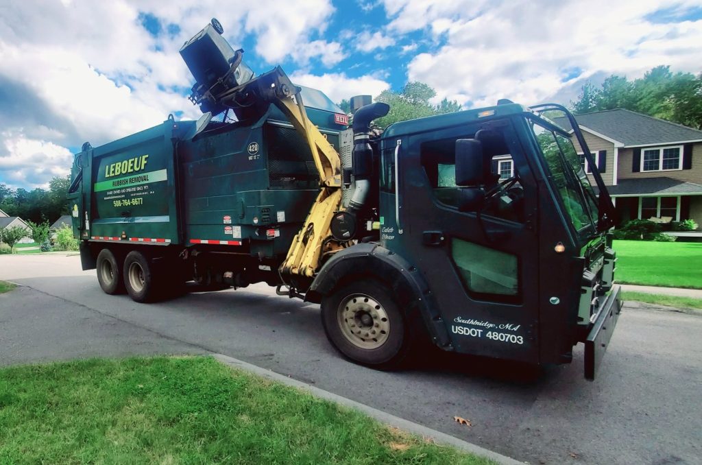 LeBoeuf garbage truck dumping a garbage bin into its side-loader.