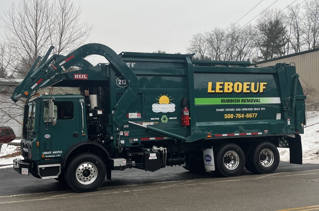A LeBoeuf front loading truck for use with garbage and recycling dumpsters.