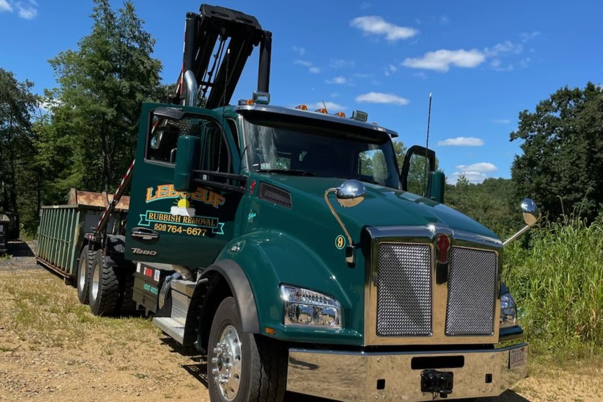 Roll off truck loading dumpster for rental services.