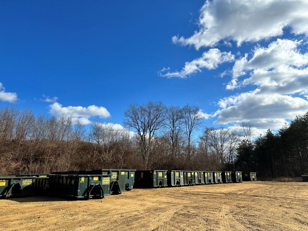 It’s hard to see from the front, but we’ve got an extensive lot, including parking for vehicles, carts, and row and row of dumpsters waiting for commercial use or rental.