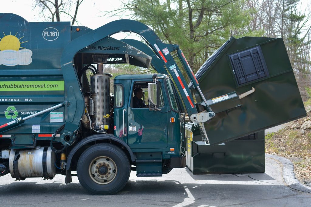 These trucks use a hydraulically powered lifter with arms or forks to pick up the dumpster and dump the contents directly into the hopper on the top of the truck. Our front-loader trucks have a capacity of 40 tons!]