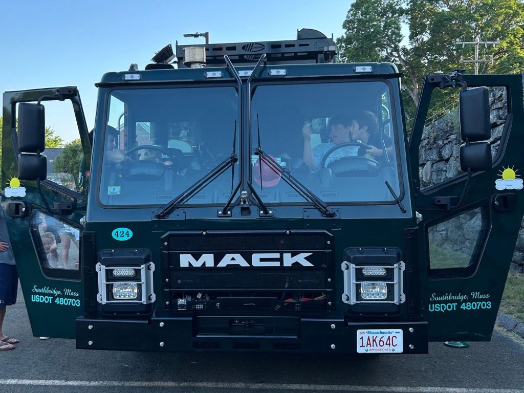 Here, our own Caleb LeBoeuf points out key features in our 2024 Mack LR Side Loader (#424) truck. Kids were most interested in why it has two steering wheels—this new-model truck has a modified transmission to be able to drive from both sides of the road!