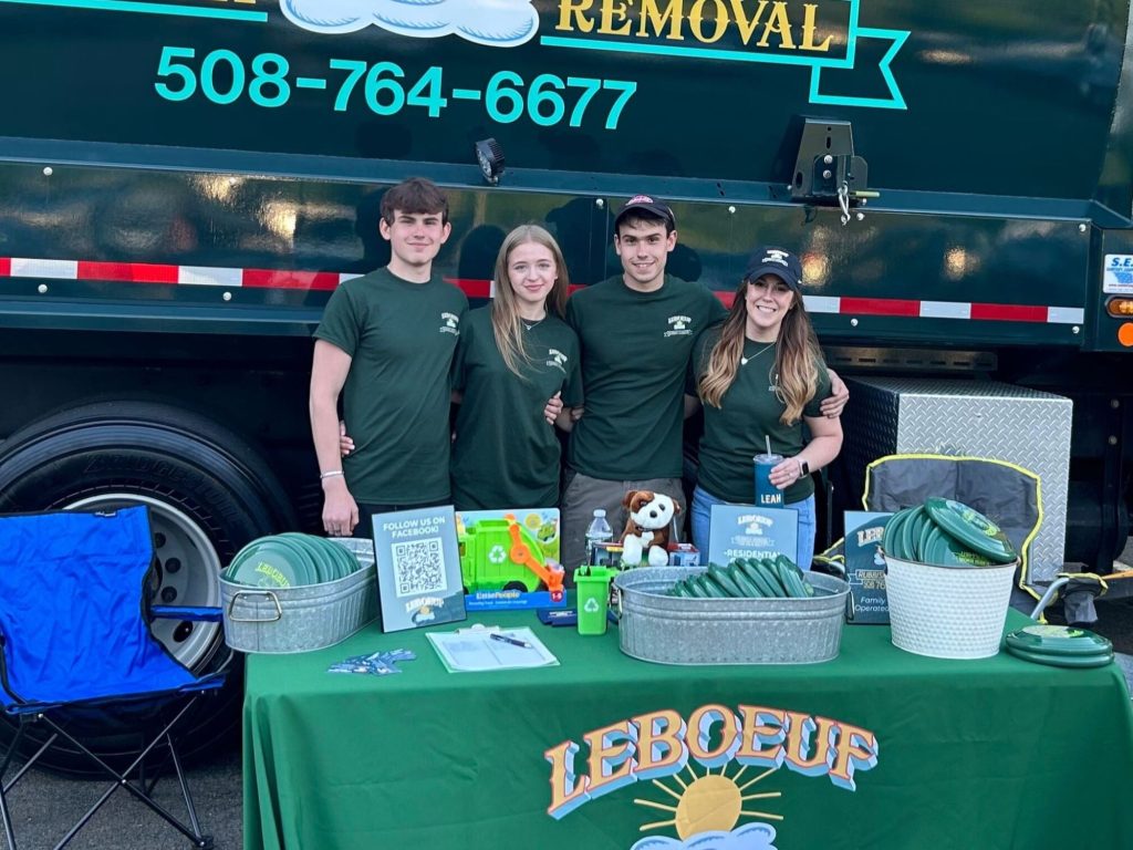 The full LeBoeuf team crewing our truck and table at the event, handing out bags, footballs, frisbees, koozies, business cards, and ice-cold water. From left to right: Ethan LeBoeuf, Martyna, Caleb LeBoeuf, and Leah!