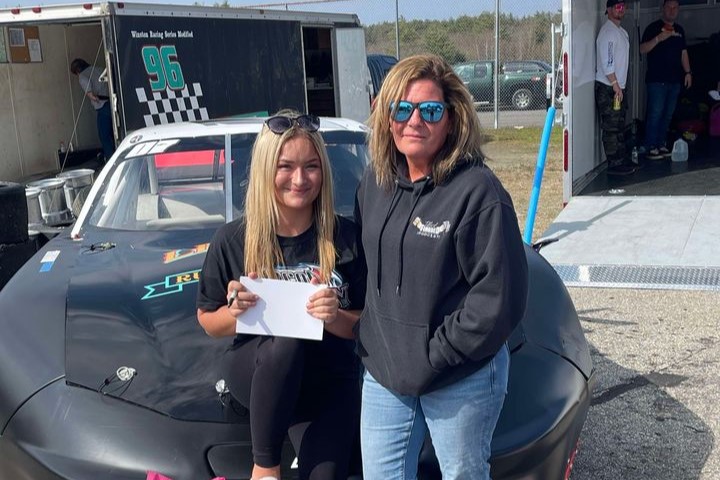 Trinity Provost and mother posing in front of #07 racing car.